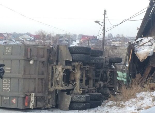 В красноярской Покровке КаМАЗ врезался в столб, дом и опрокинулся