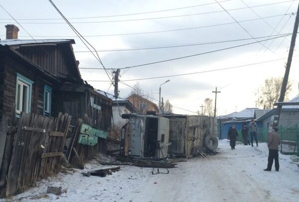 В красноярской Покровке КаМАЗ врезался в столб, дом и опрокинулся